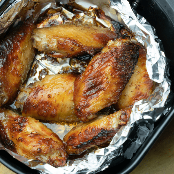 Closeup of chicken wings in an air fryer.