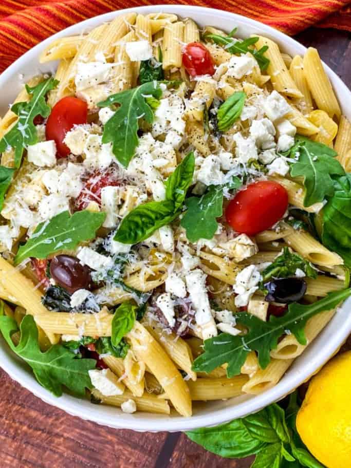 vertical picture of pasta salad with mediterranean ingredients