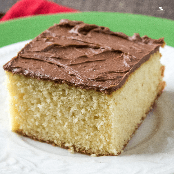 piece of yellow sheet cake with chocolate frosting in a plate