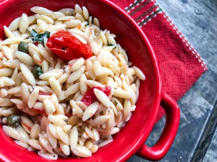 vegan orzo pasta salad in a red bowl