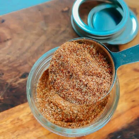 measuring out the taco seasoning with a tablespoon