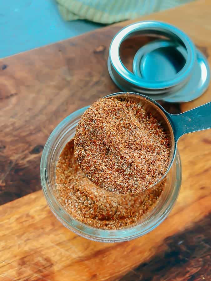 measuring out the taco seasoning with a tablespoon