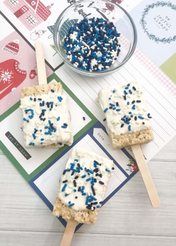 three Frozen Themed Rice Krispie Treats beside bowl of sprinkles