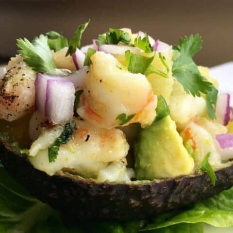 close-up picture of avocado shell stuffed with shrimp and pineapple mixture