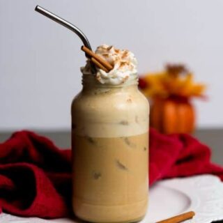 vegan pumpkin latte served over ice in a tall glass