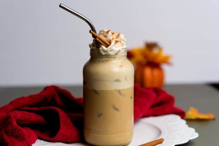 vegan pumpkin latte served over ice in a tall glass