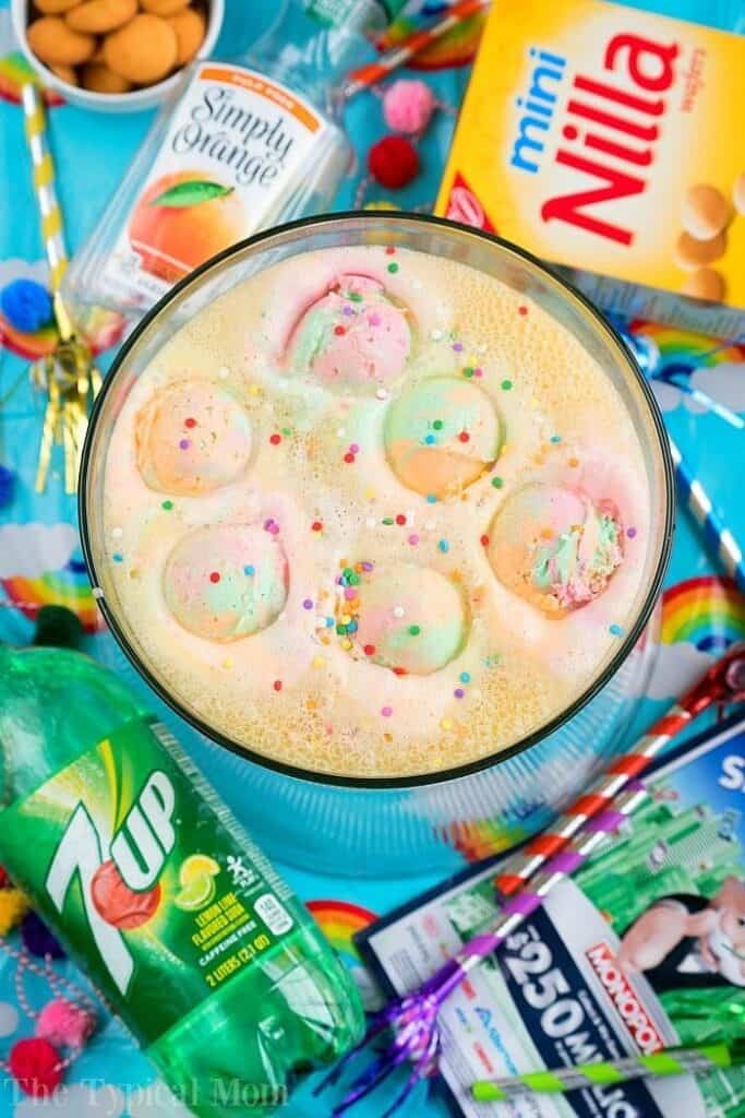 bowl of orange party punch with rainbow sherbet and sprinkles