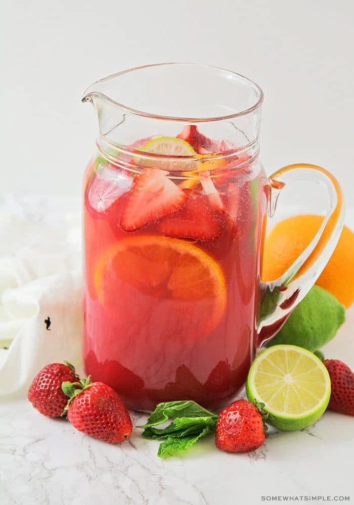 sangria punch in a pitcher surrounded by fruit