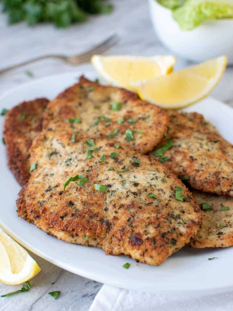 breaded italian chicken cutlets on white plate