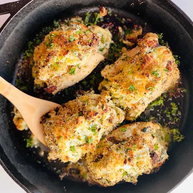 spinach artichoke chicken in a frying pan