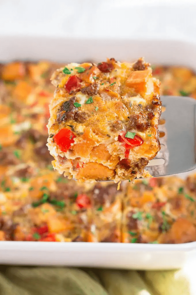 sweet potato breakfast casserole in white dish with some on spatula