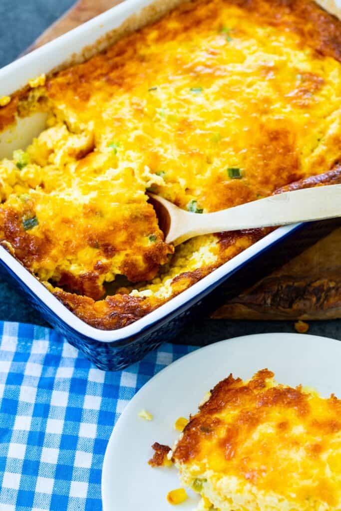 three cheese corn pudding in white plate and white bakeware