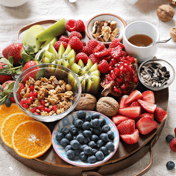 healthy board including granola, fruits, and berries.