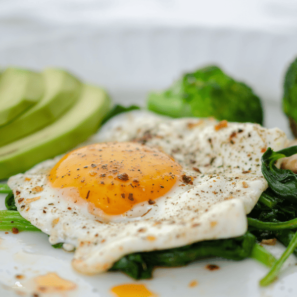 Healthy homemade breakfast with eggs mushroom broccoli and spinach.