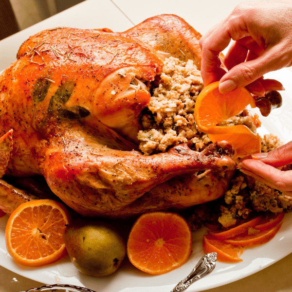 Roasted turkey garnished with fruits.