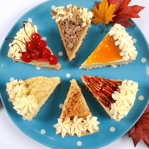 Slices of Thanksgiving pies on a blue plate. Apple, pecan, cherry, cream cheese, pumpkin spice, chocolate pie.