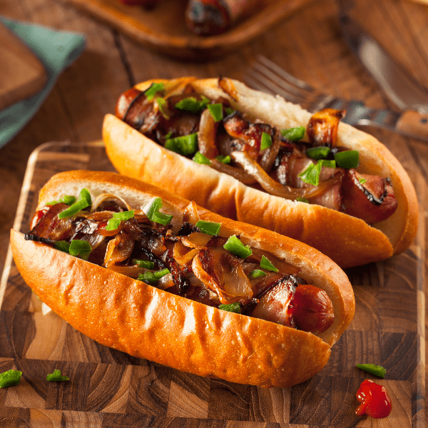 Homemade bacon wrapped hot dogs with onions and peppers.