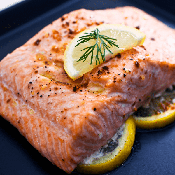 Baked salmon ontop of lemons.