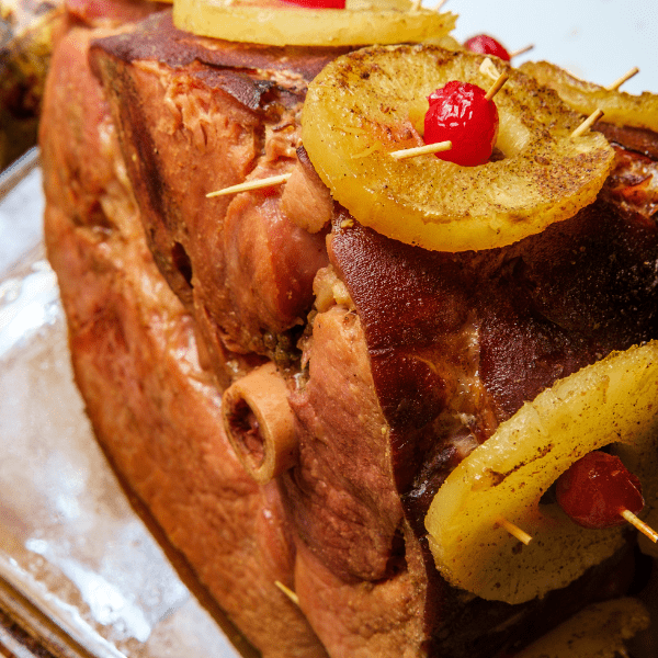 Roasted bone-in ham with pineapples and maraschino cherries.