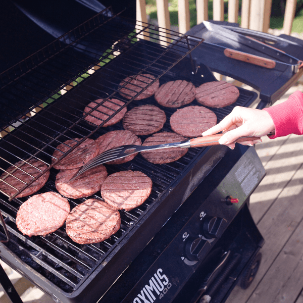 Woman grilling burgers.