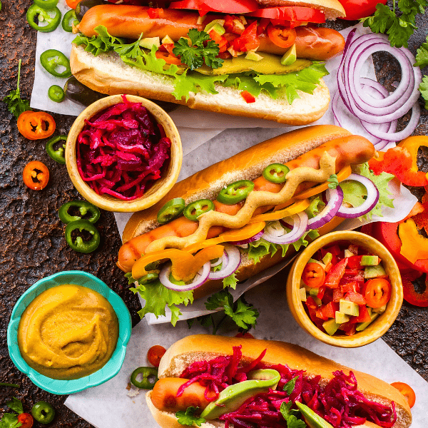 hot dogs with toppings on a dark background