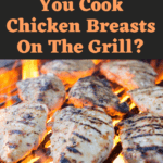 chicken breast cooking in a charcoal grill on flame with text: "How Long Do You Cook Chicken Breasts On The Grill?" above on a dark background