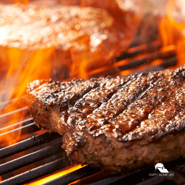 steaks cooking on flaming grill panorama