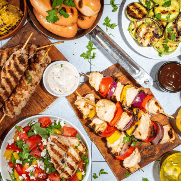 Grilled summer bbq dishes on a picnic table.