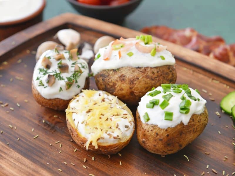 sour cream on baked potatoes with different toppings