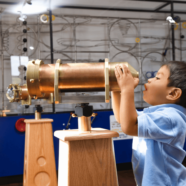 boy looking into a telescope in a museum