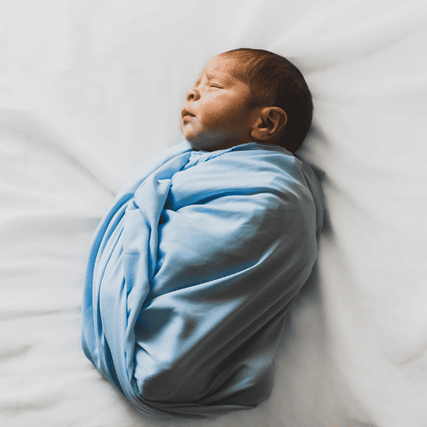 Photo of newborn baby covered with a blue blanket.
