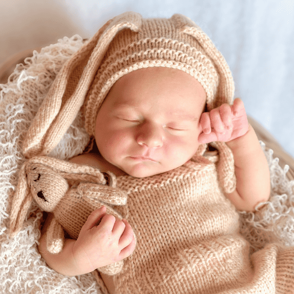 Newborn holding a teddy bear.