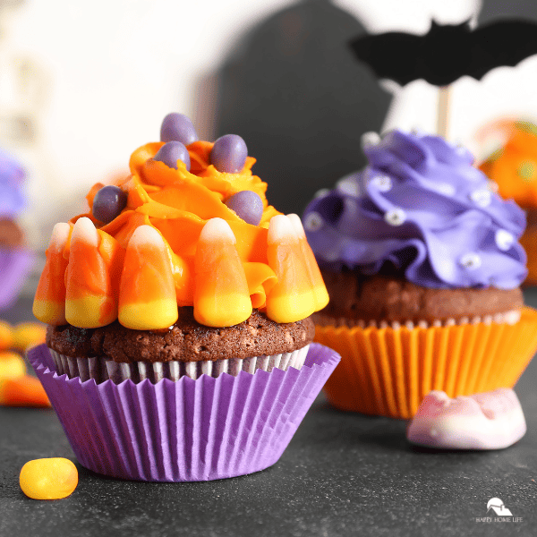 A close-up shot of a candy corn cupcake with another cupcake in the background.