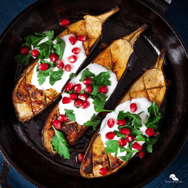 An image of baked eggplants with yogurt and pomegranate seeds.