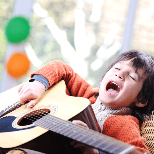 Kid singing and playing guitar at home.