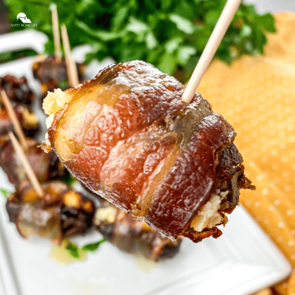 Close up image of Bacon Wrapped Stuffed Dates in a white plate