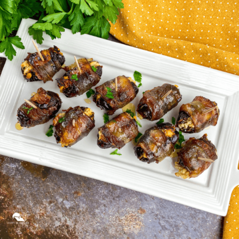 Bacon Wrapped Stuffed Dates in a white plate – square size