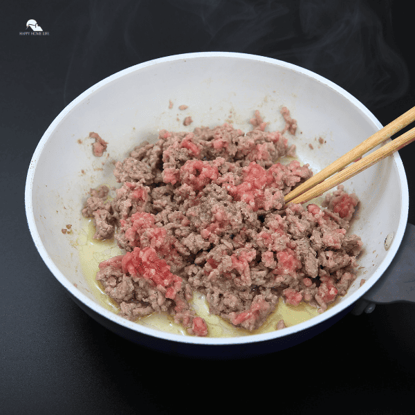 an image of ground pork in a white frying pan