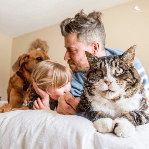 a father and a daughter petting the dog and cat