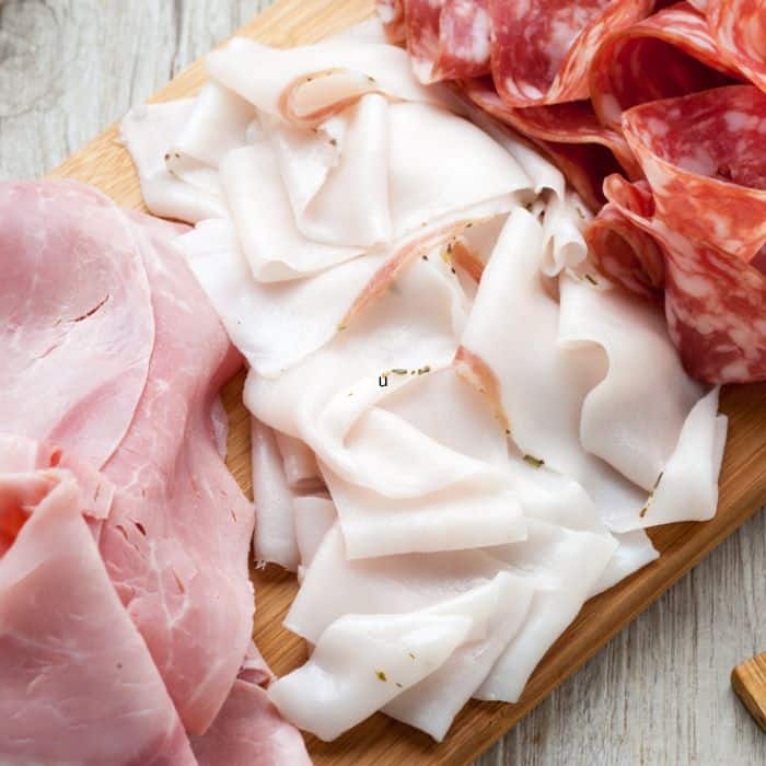 image of thinly sliced deli meat on wooden serving board