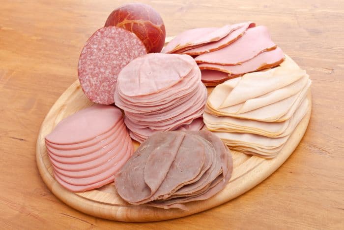 big selection of deli meats on an oval serving board
