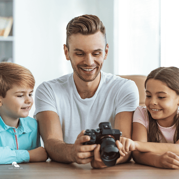 dad and kids holding a camera