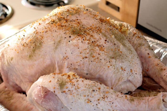 fresh uncooked turkey sprinkled with seasoning