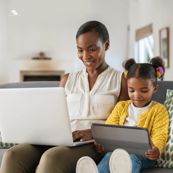Woman Working from Home While Her Daughter Using Digital Tablet