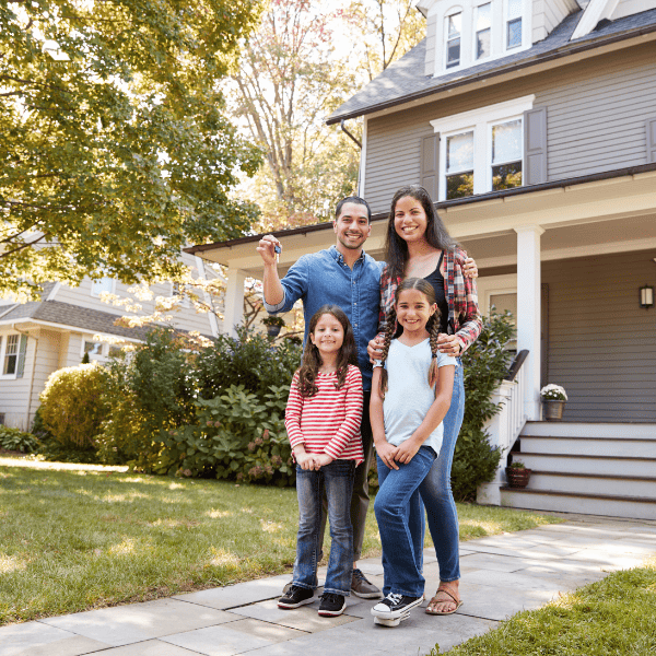 family outside their new home holding a key