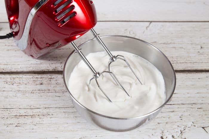 whipped cream in mixing bowl with red mixer off to the side