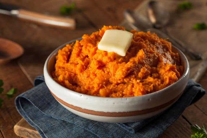 bowl of mashed sweet potatoes topped with butter