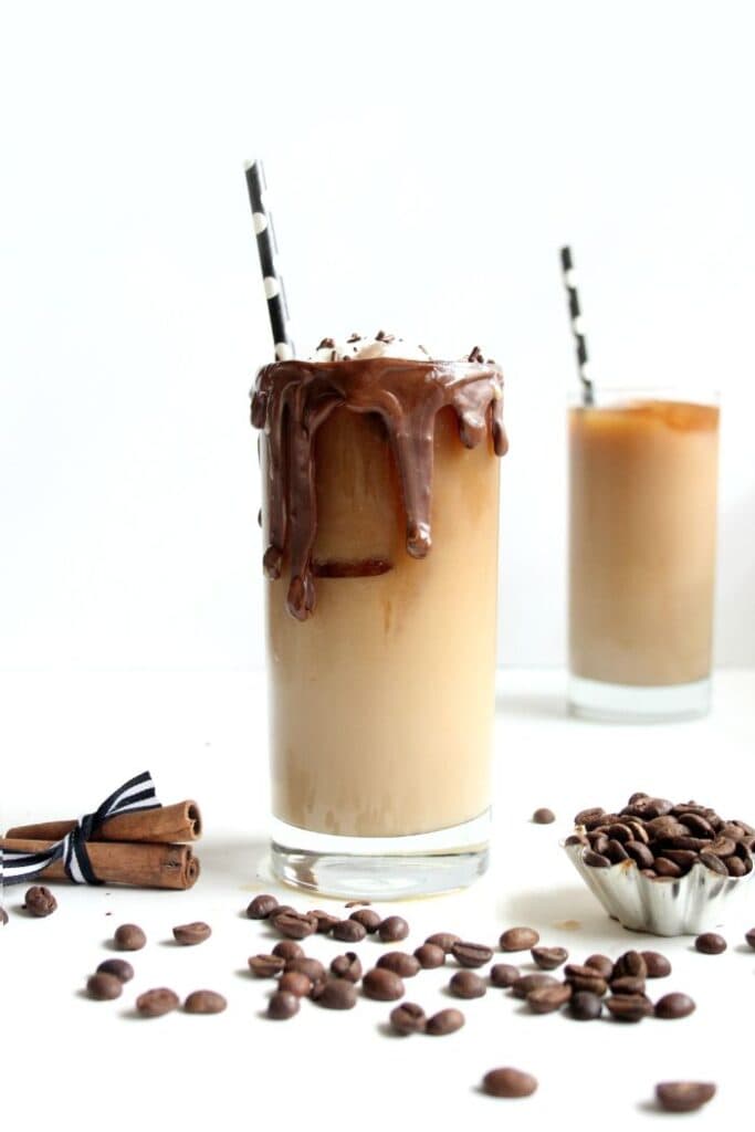 vanilla cinnamon iced coffee with chocolate sauce on rim of glass