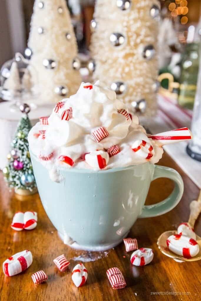 white cocoa peppermint latte topped with lots of whipped cream and peppermint candies