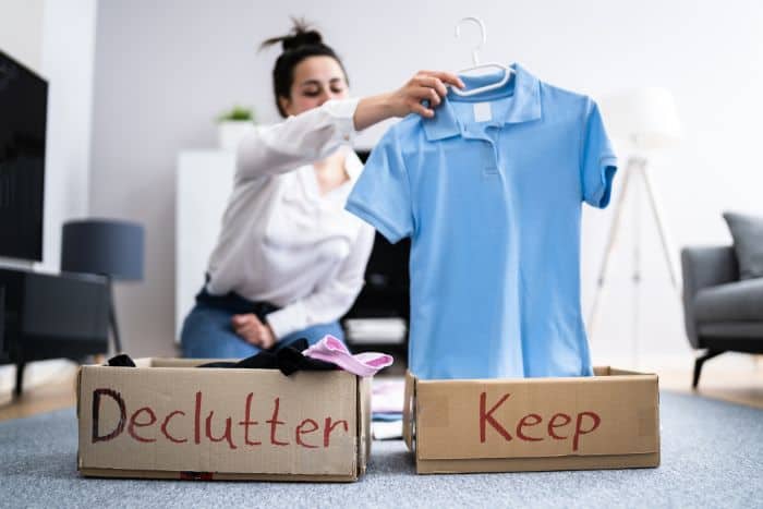 woman sorting clothes into keep or declutter boxes